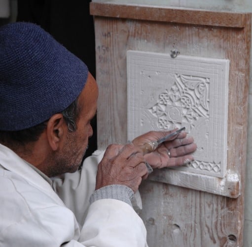 man sculpting, creating physical texture