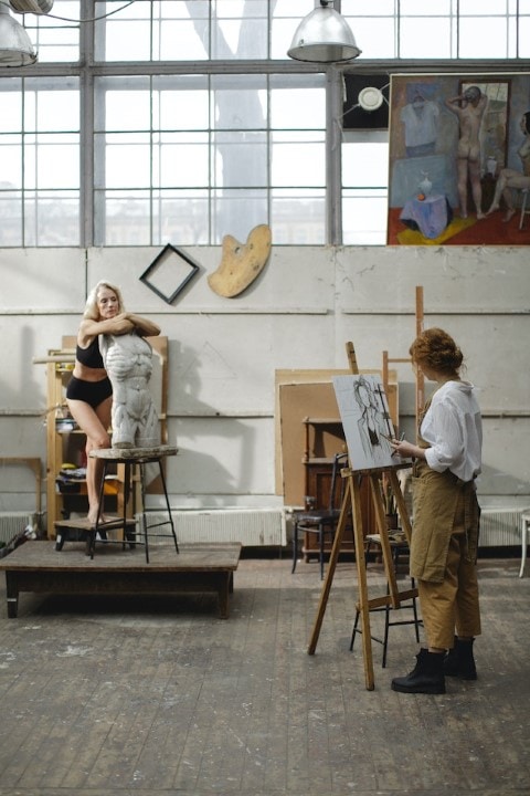 photo of a woman drawing a live model