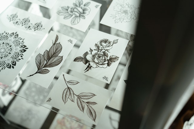 Paper sheets with different tattoo drawing examples drawn